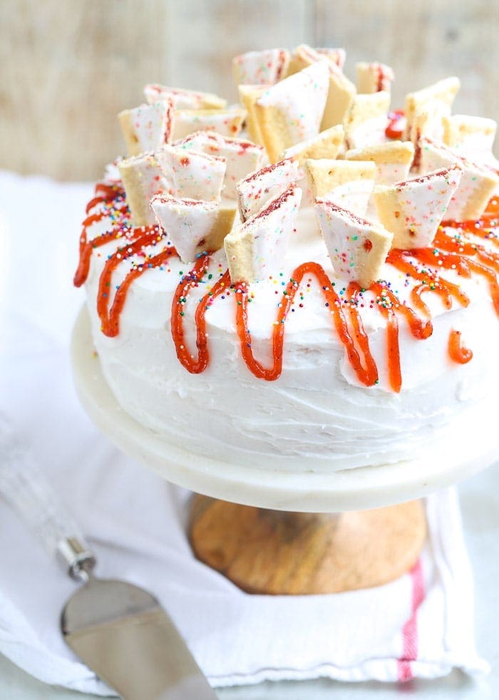 Strawberry Pop Tart cake decorated with strawberry sauce and Pop Tart pieces.