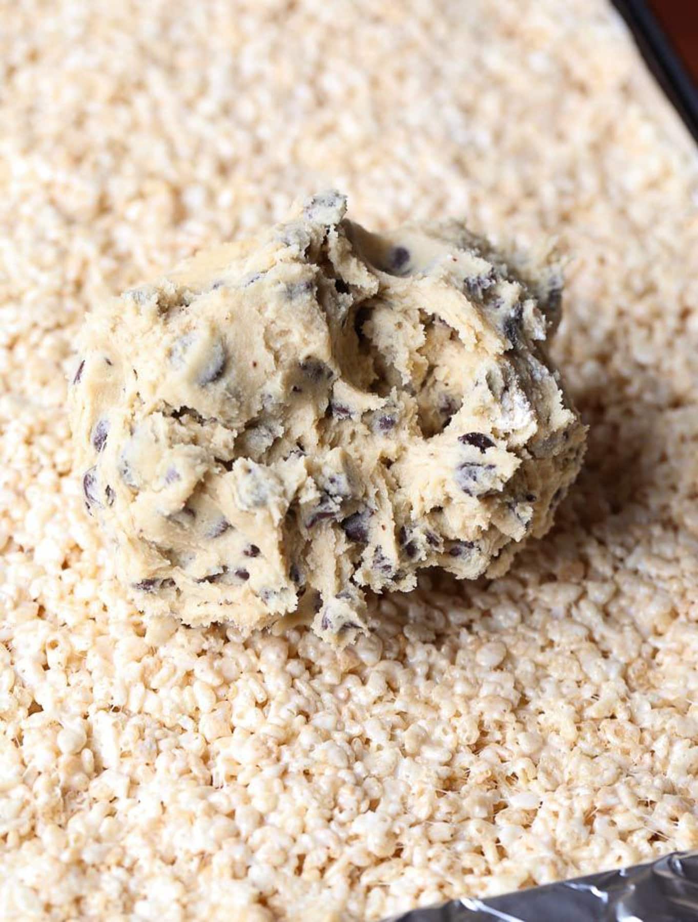 Putting cookie dough on top of rice krispie treats