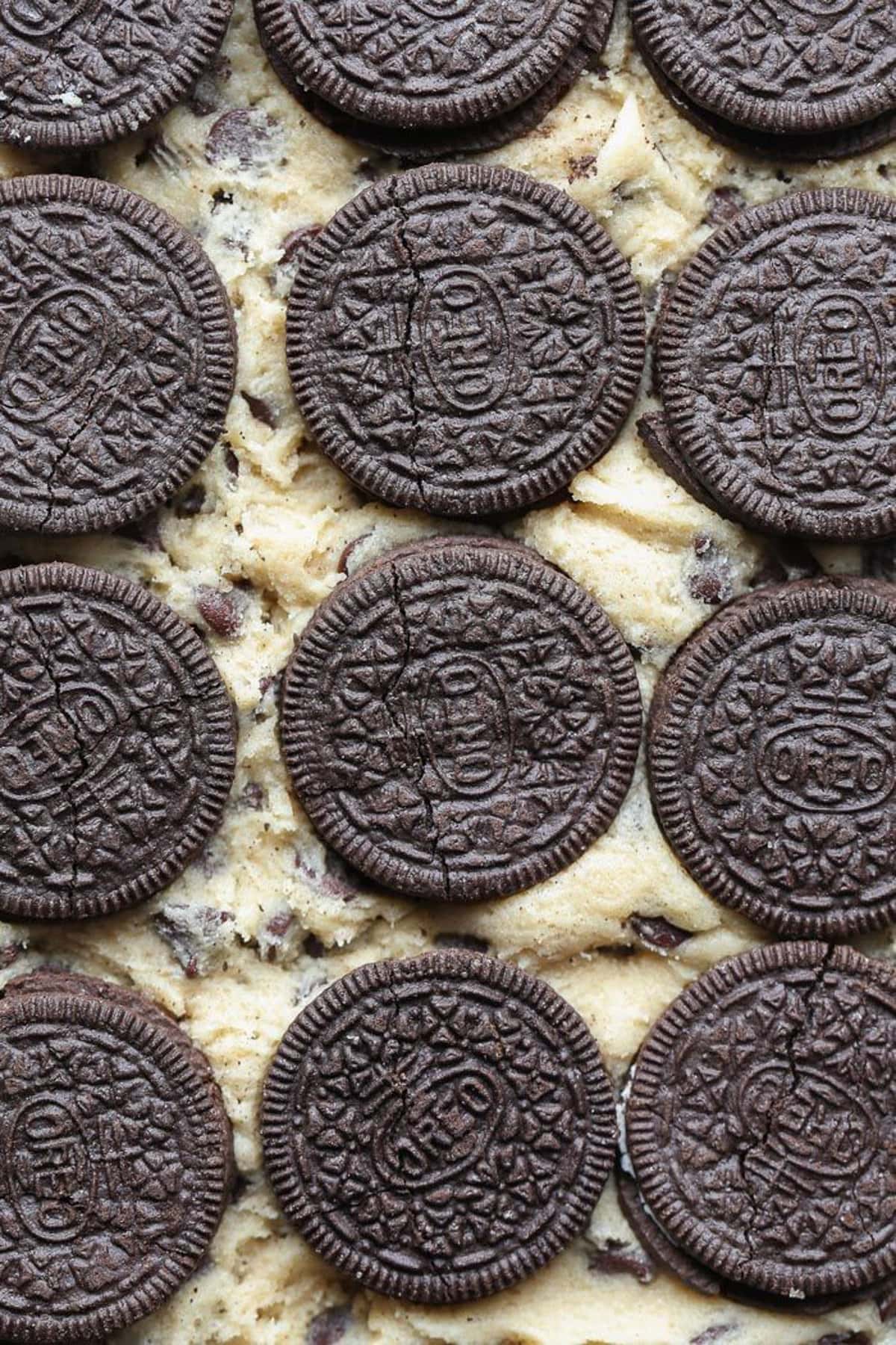 Putting oreos on top of cookie dough 
