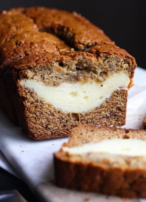 Cheesecake Stuffed Banana Bread...it's a classic treat turned on it's head. The thick ribbon of cheesecake is creamy, rich and the perfect pairing with the buttery banana bread!