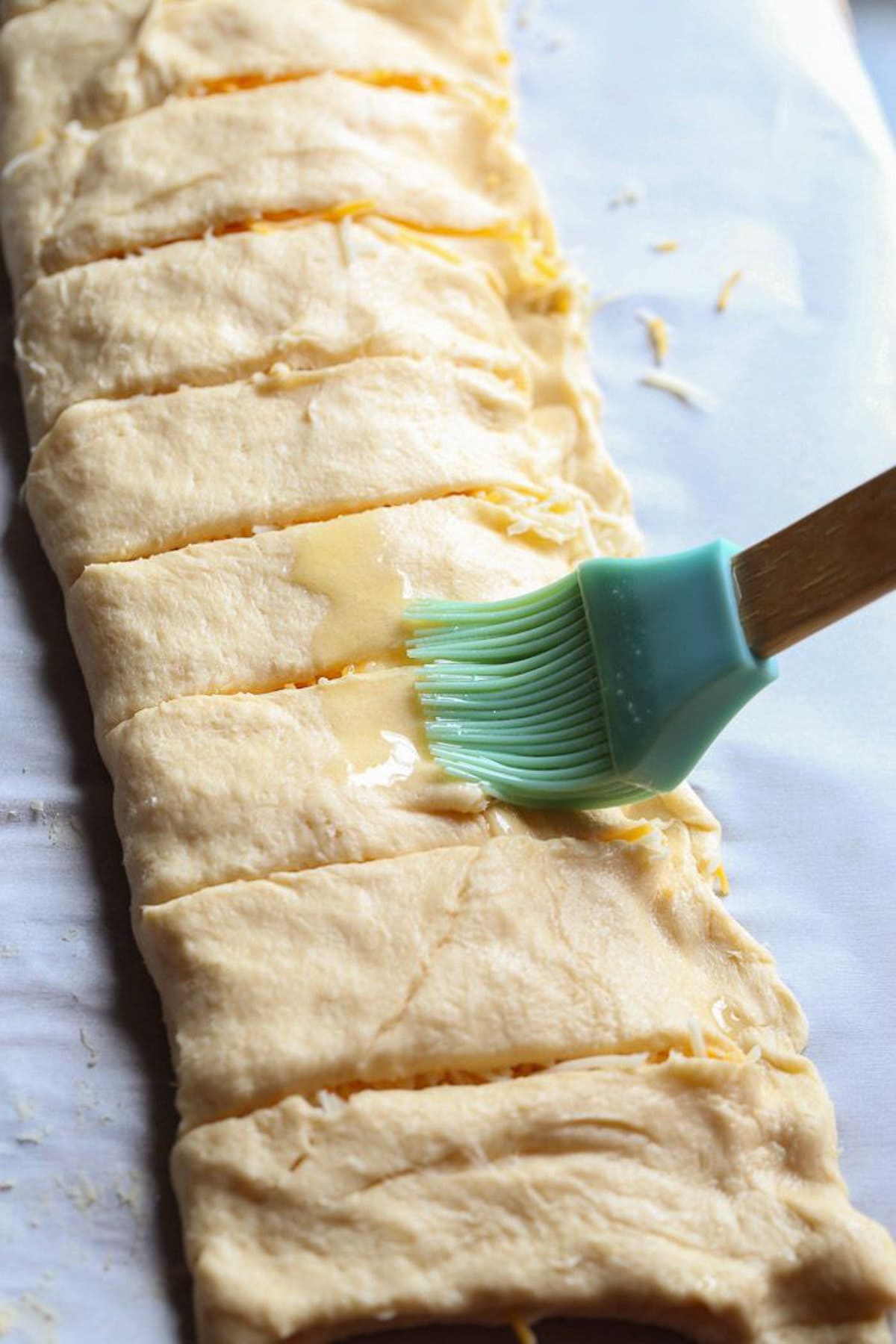 brushing butter onto breadsticks before baking