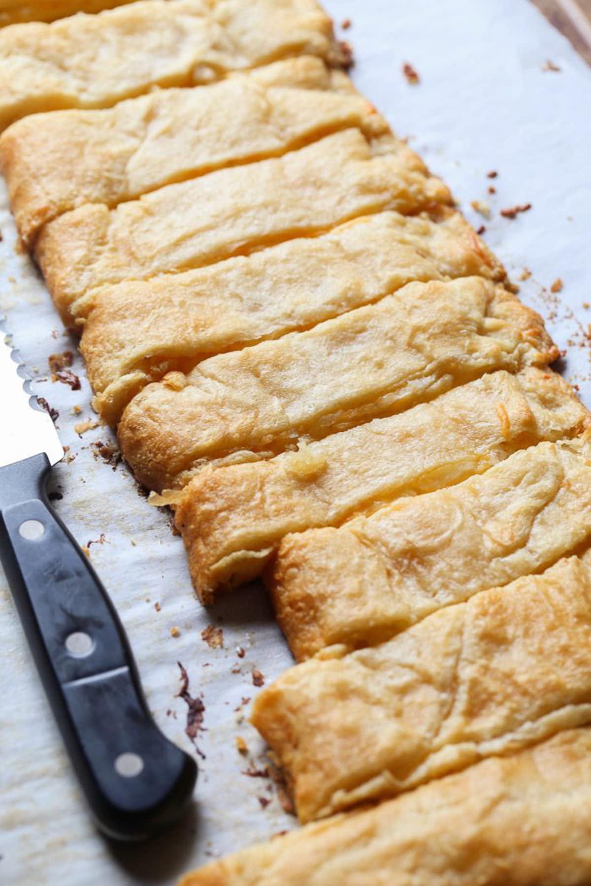 baked cheese stuffed breadsticks on a parchment lined baking sheet