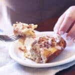 A serving of Cinnamon Roll Breakfast bake on a plate with a bite on a fork