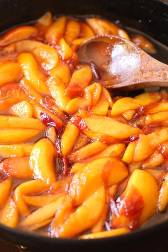 This easy skillet peach cobbler is made in one pan and topped with a chewy sugar cookie crumble. An easy, fun twist on a classic dessert! Peaches caramelized in sugar