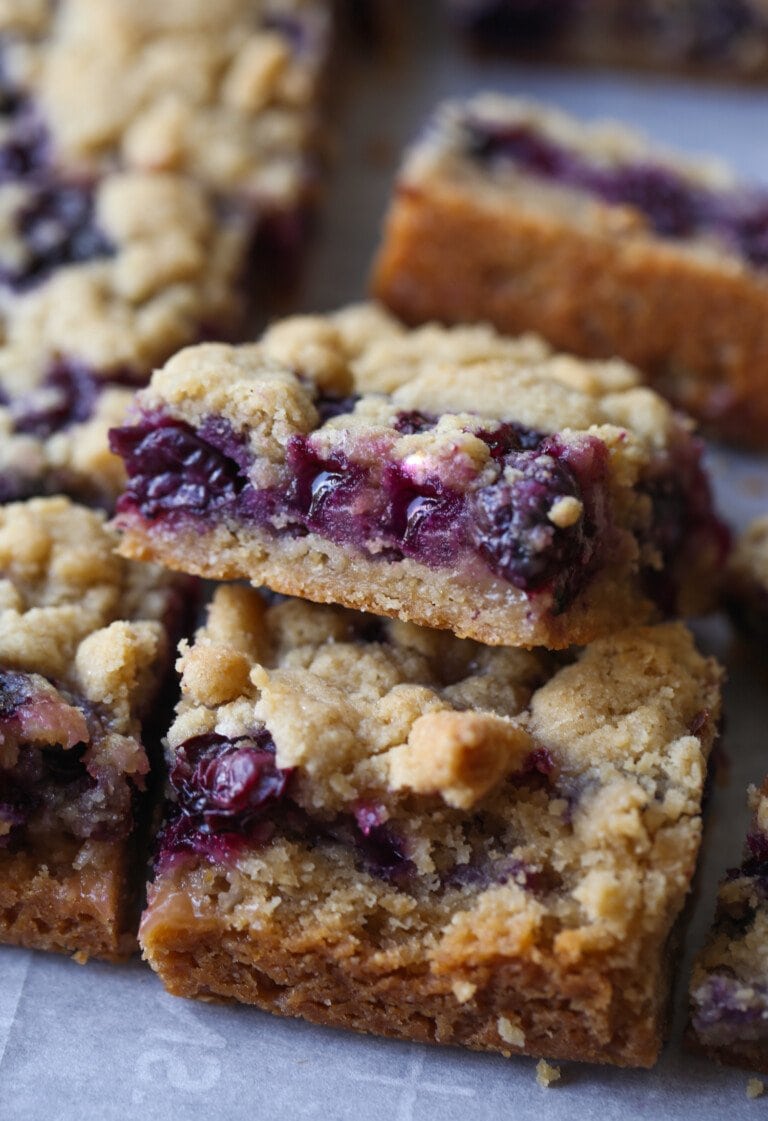 Close up of Blueberry Crumb Bars stacked on a countertop.