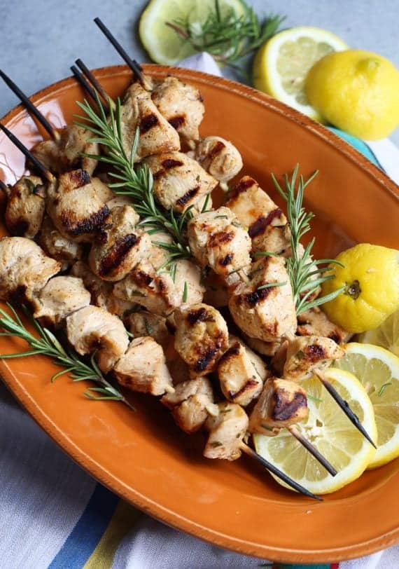 Grilled Chicken on skewrs with rosemary sprigs and lemon slices 