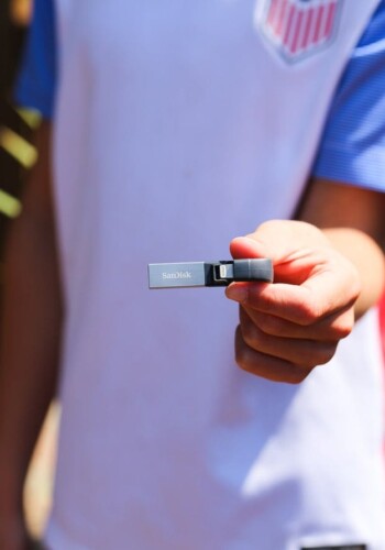 A hand holding a sandisk memory stick