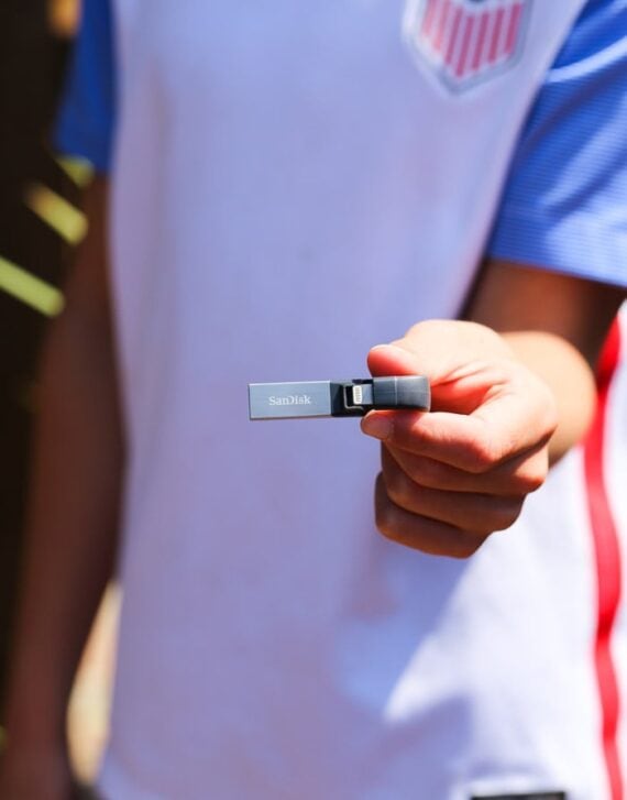 A hand holding a sandisk memory stick