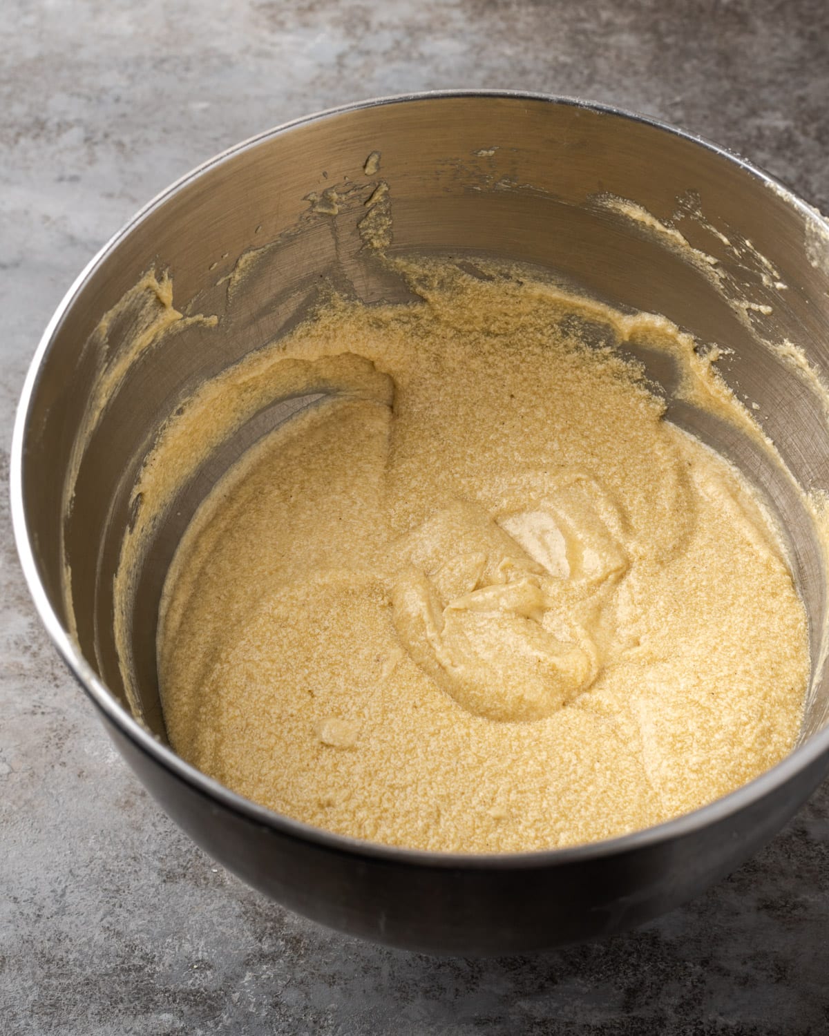 Vanilla cake batter in a metal mixing bowl.