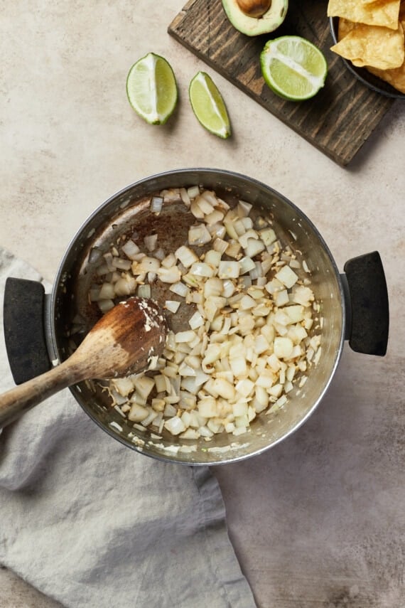 Onions and garlic are sauted in a pot.