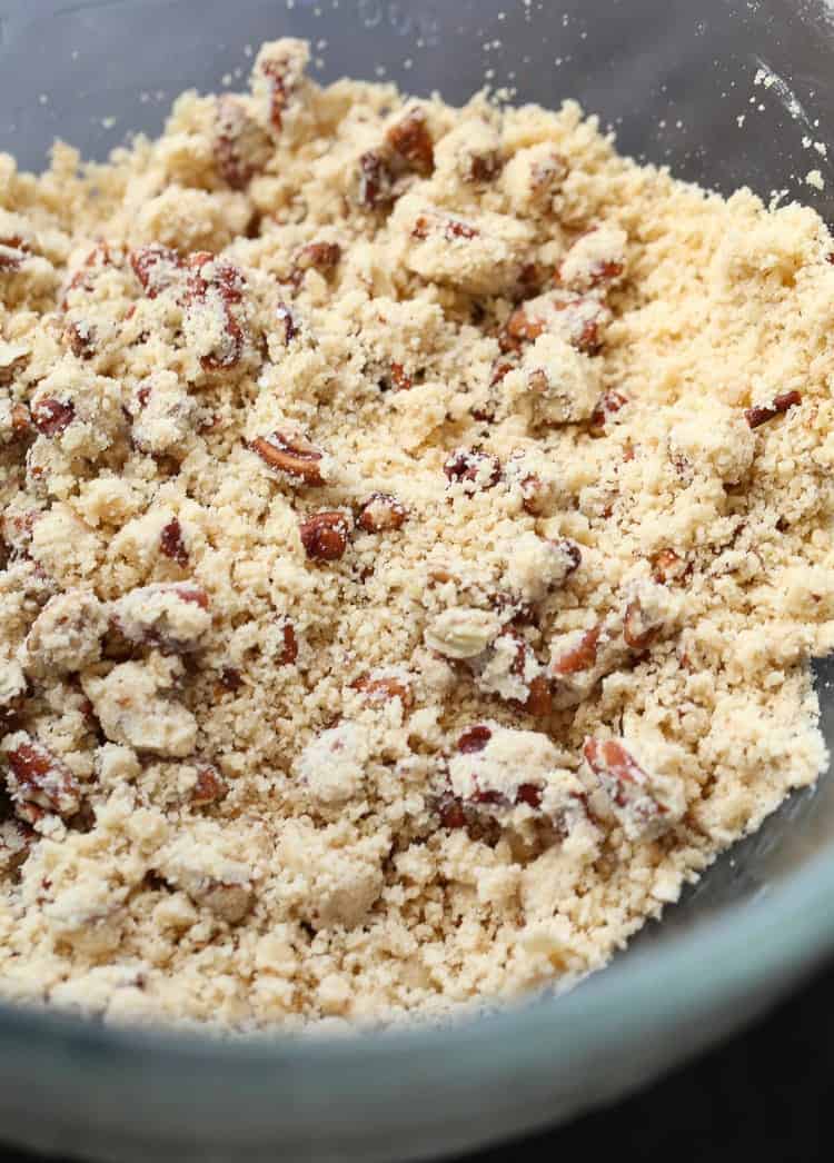 Flour, butter, pecans, and brown sugar are mixed together to make a praline crumble
