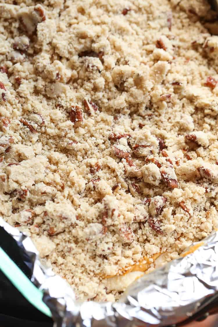 Cream Cheese Pumpkin Bars topped with a Praline crumble, ready to bake in a foil-lined pan