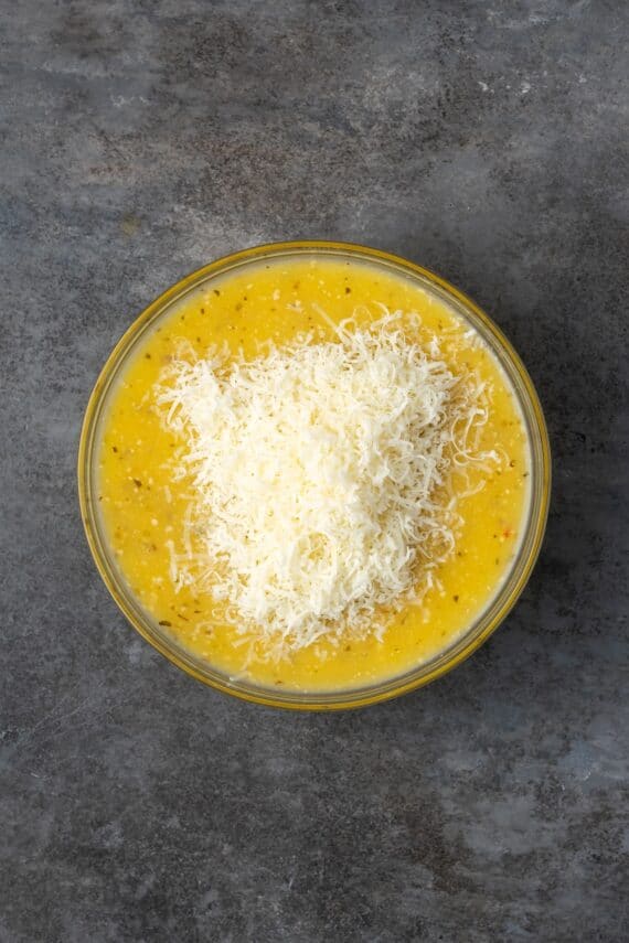 Parmesan cheese added to a bowl of Italian dressing.