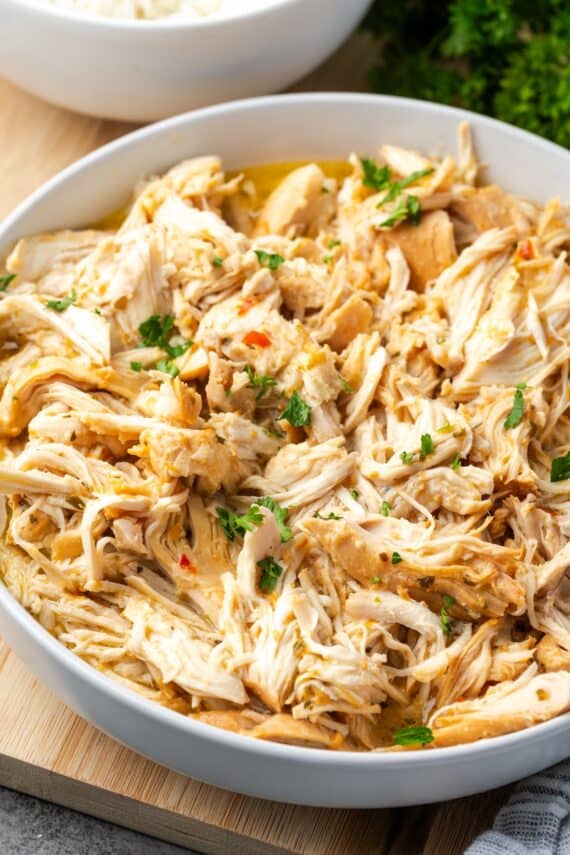 Chopped slow cooker Italian chicken in a large bowl.