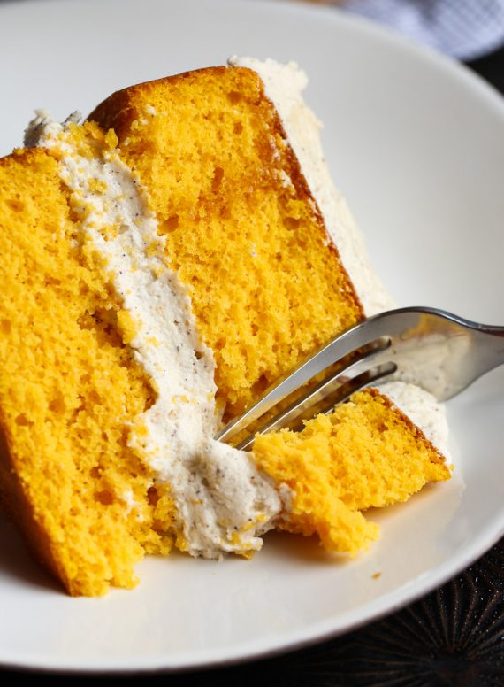 A slice of pumpkin cake with a fork taking a bite