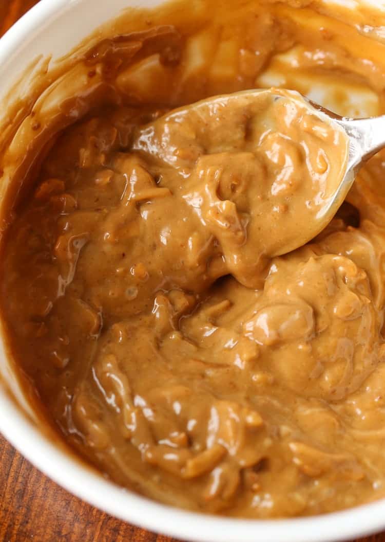 A mixture of French onion mix and mayonnaise in a bowl with a spoon to be used for chicken salad