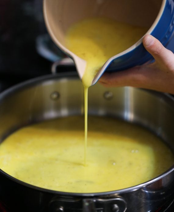 Egg mixture being poured into a pan for Maple Sausage Breakfast Sliders