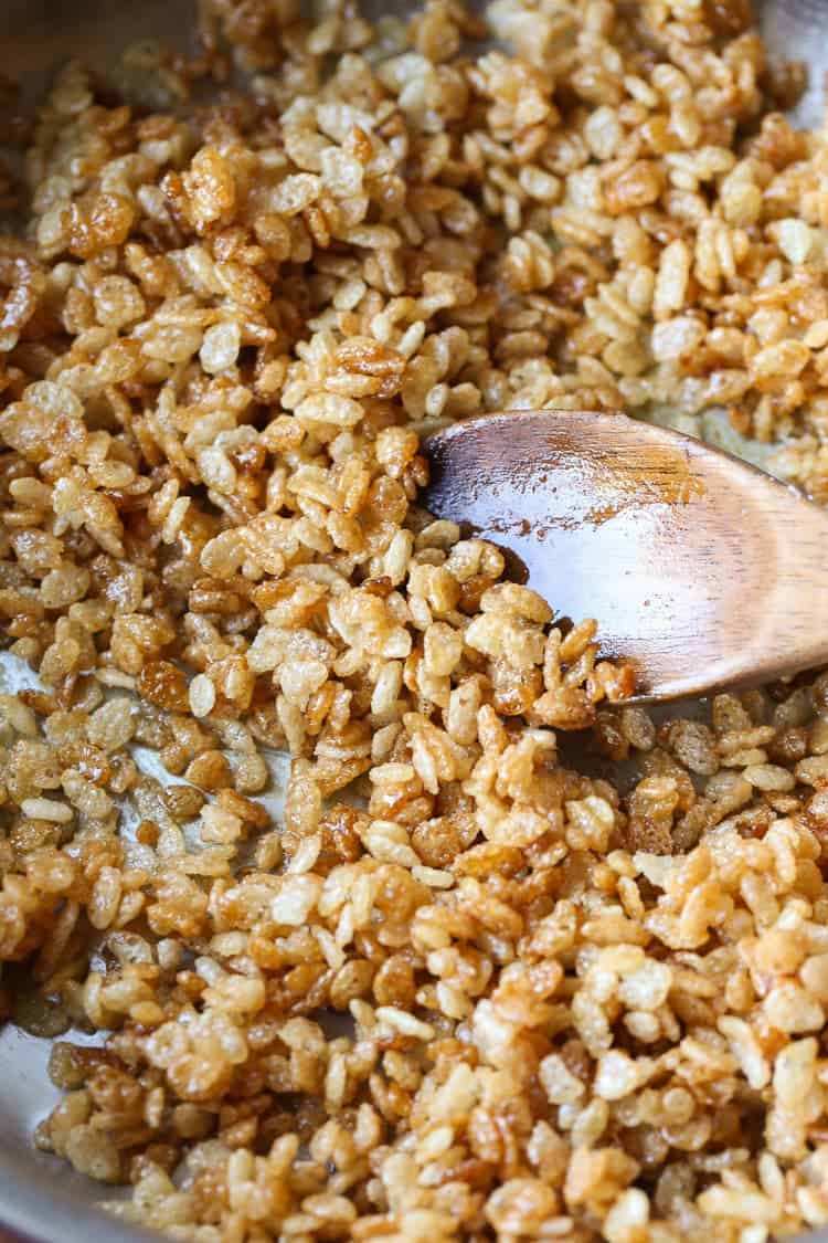 Caramelized Rice Krispies Being Stirred Around with a Wooden Spoon