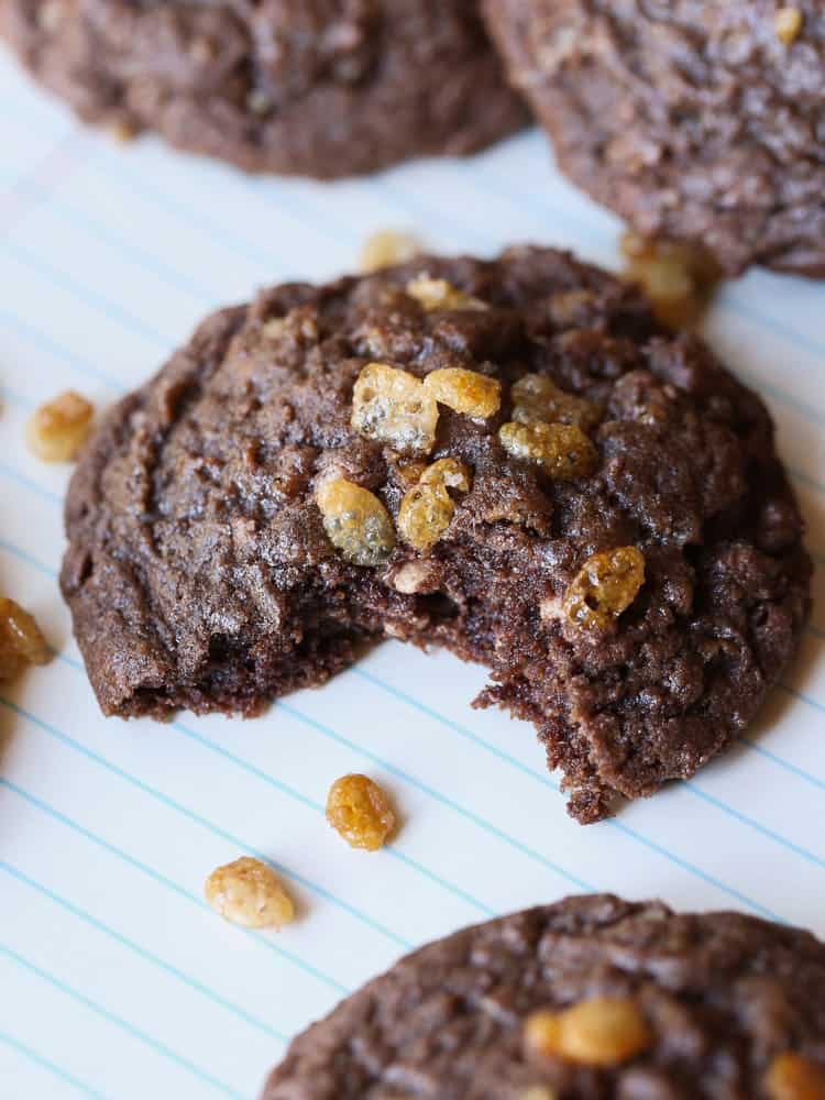 A Chocolate Crunch Cookie on a Piece of Notebook Paper with One Bite Taken Out