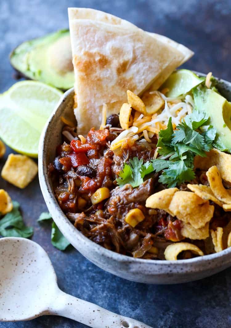 A bowl of taco truck chili with fritos and pita