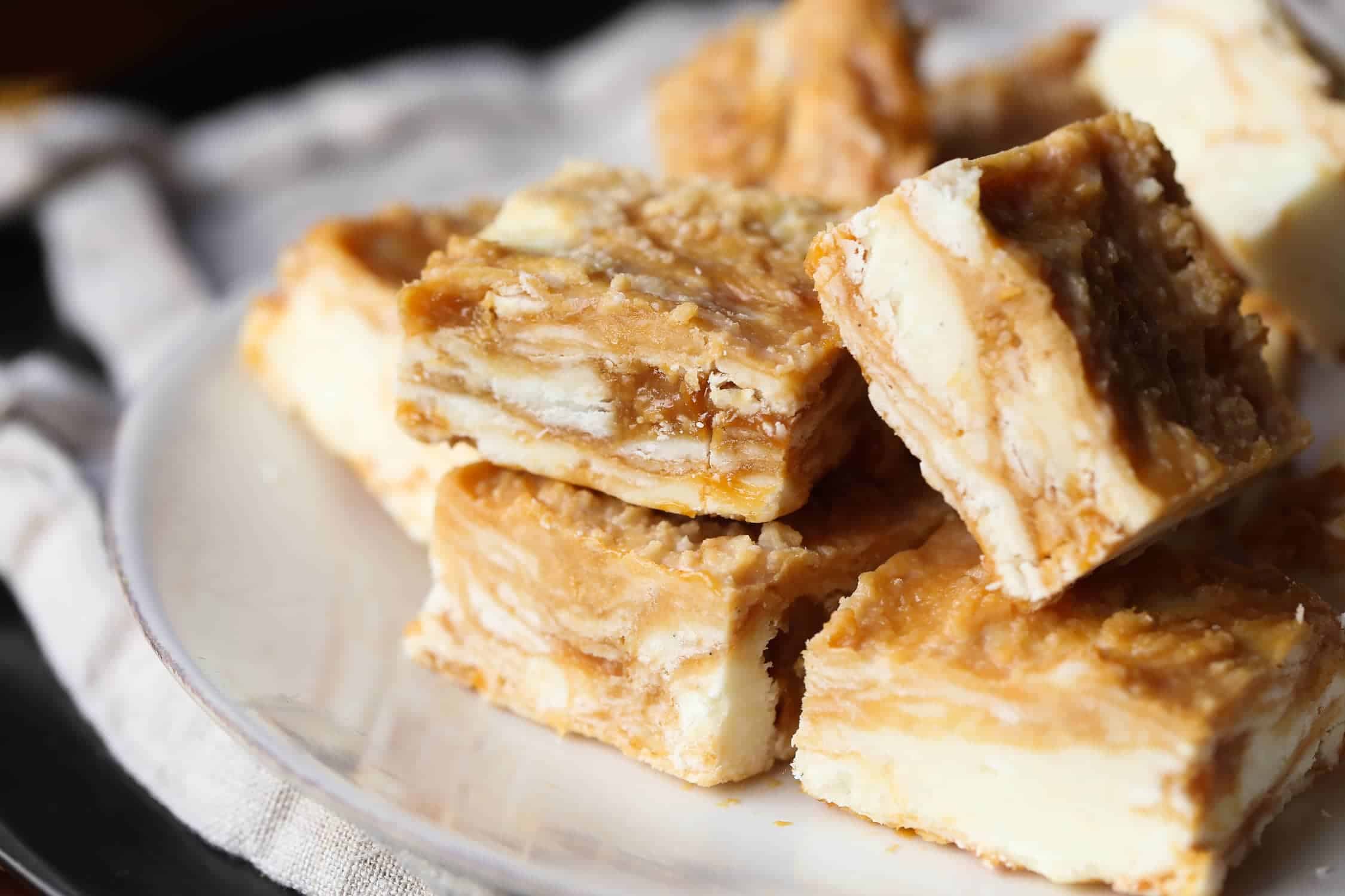 Dulce de Leche Swirled Vanilla Fudge squares stacked on a plate.