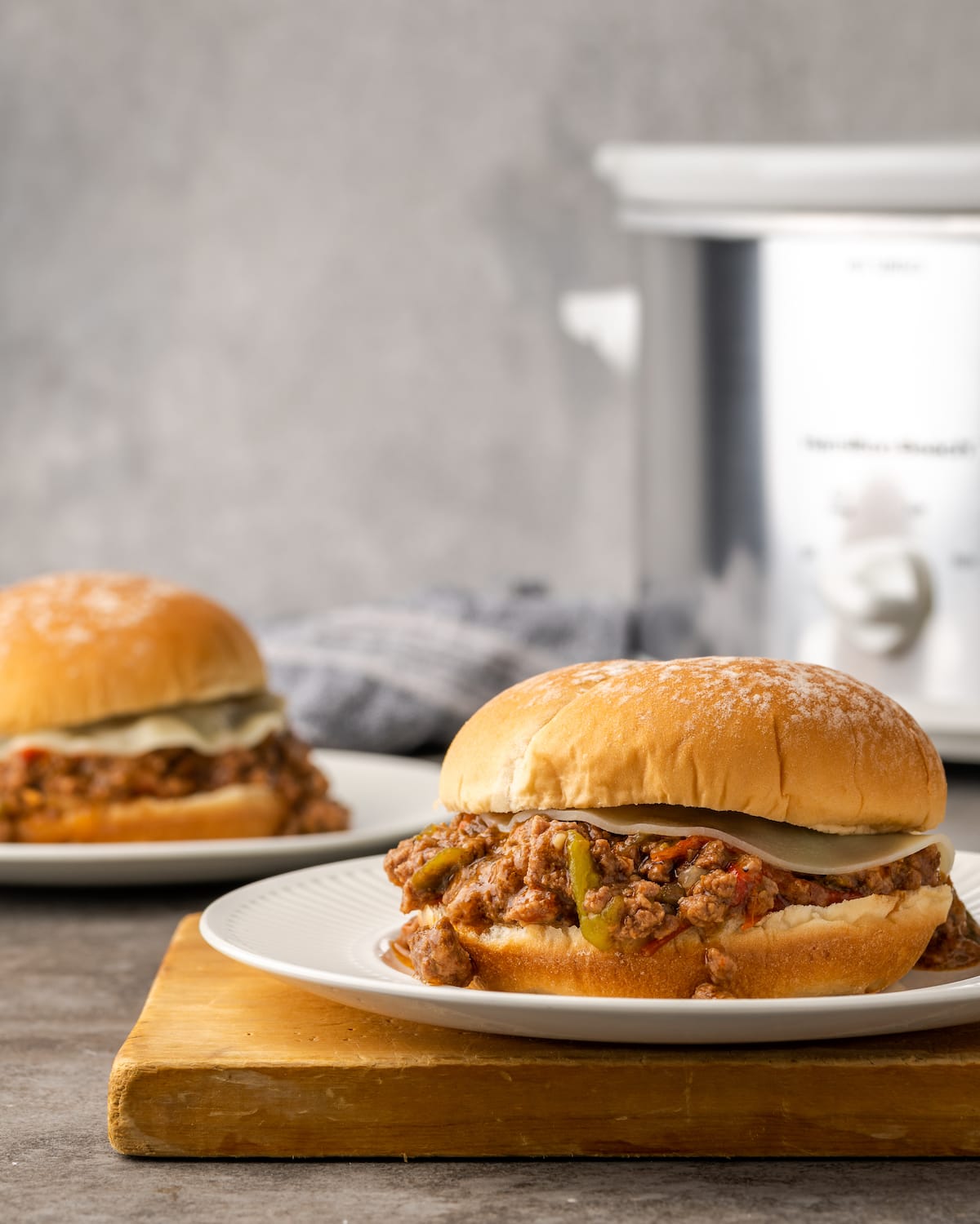 Crock Pot Philly Cheesesteak Sloppy Joes in a bun on a plate.