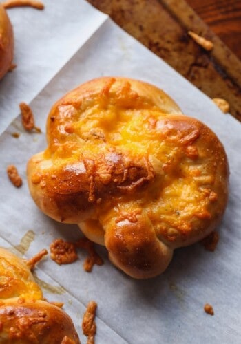 An easy "cracked out" pretzel covered in cheese, on parchment paper.