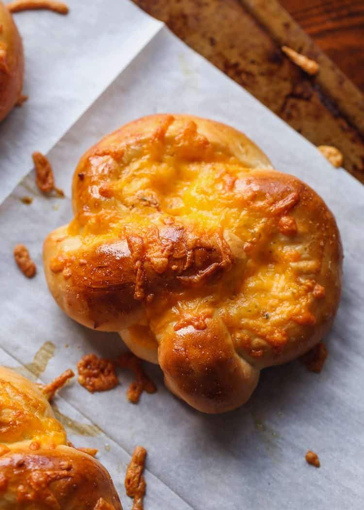 An easy "cracked out" pretzel covered in cheese, on parchment paper.