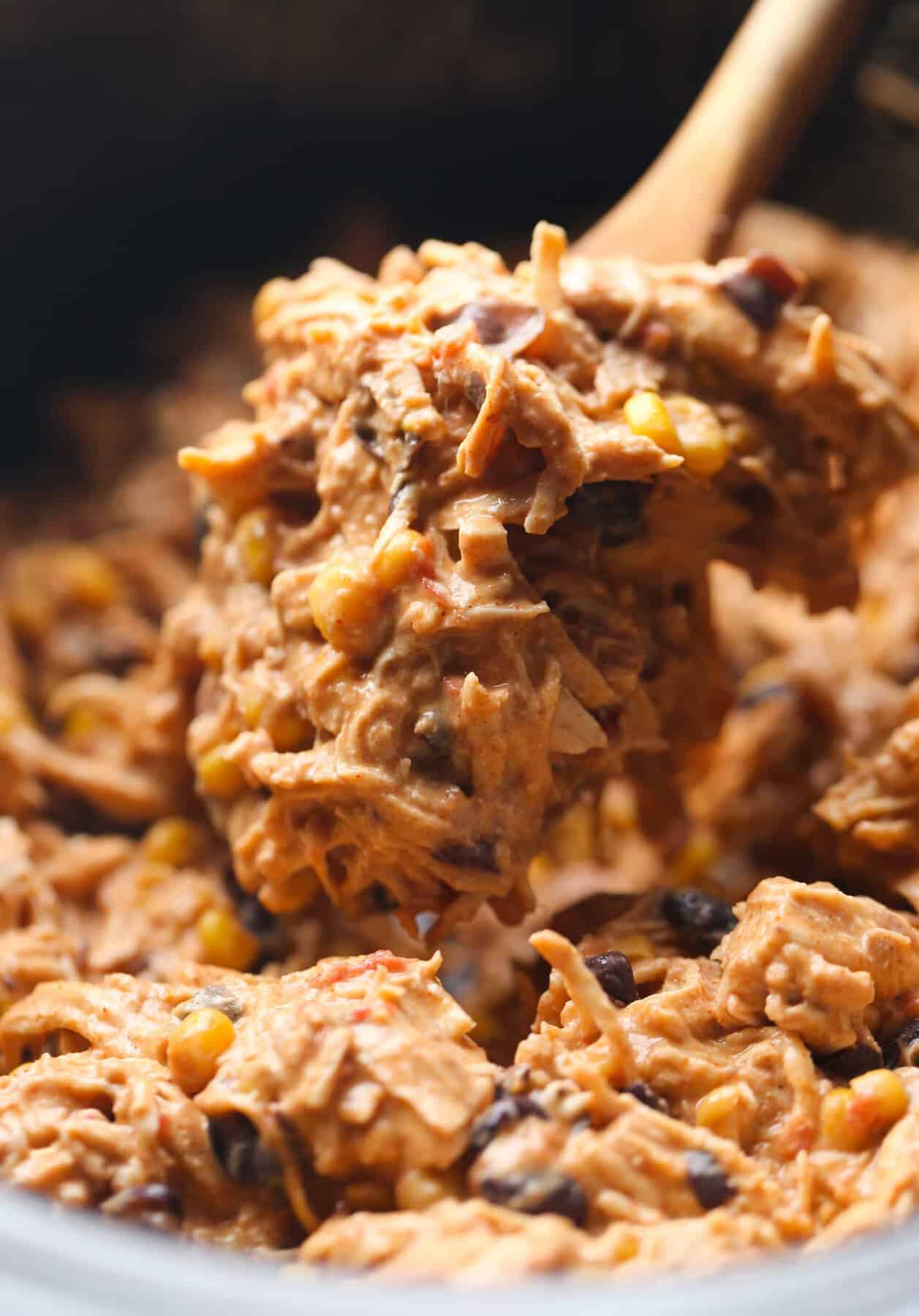 A Wooden Spoon Scooping Out a Portion of Fiesta Chicken From a Pot