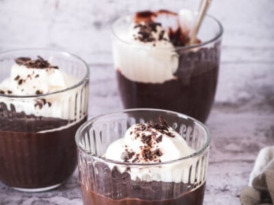 Three bowls of easy chocolate pudding with whipped cream.