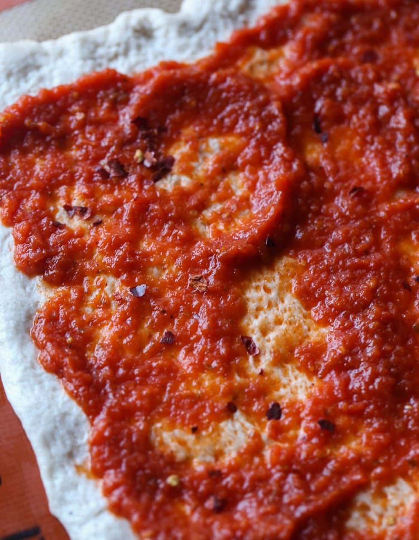 Pizza sauce spread on Pizza dough