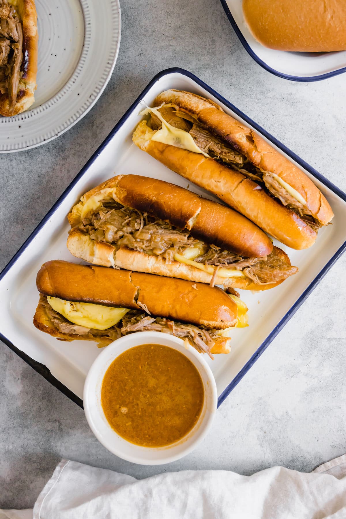Three French dip sandwiches with au jus.