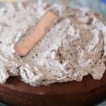 A Close-Up Shot of Oreo Frosting Being Spread Over a Chocolate Cake with a Palette Knife