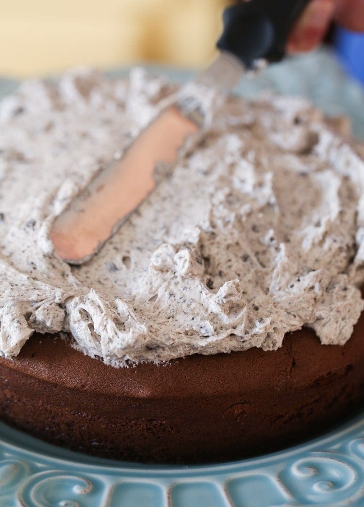 A Close-Up Shot of Oreo Frosting Being Spread Over a Chocolate Cake with a Palette Knife