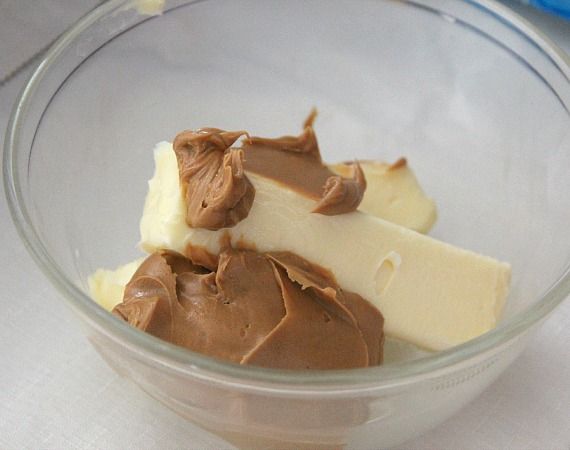 Butter and peanut butter in a glass mixing bowl