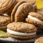 Close up of assorted key lime sandwich cookies piled on a plate.