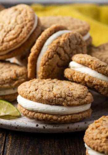 Close up of assorted key lime sandwich cookies piled on a plate.