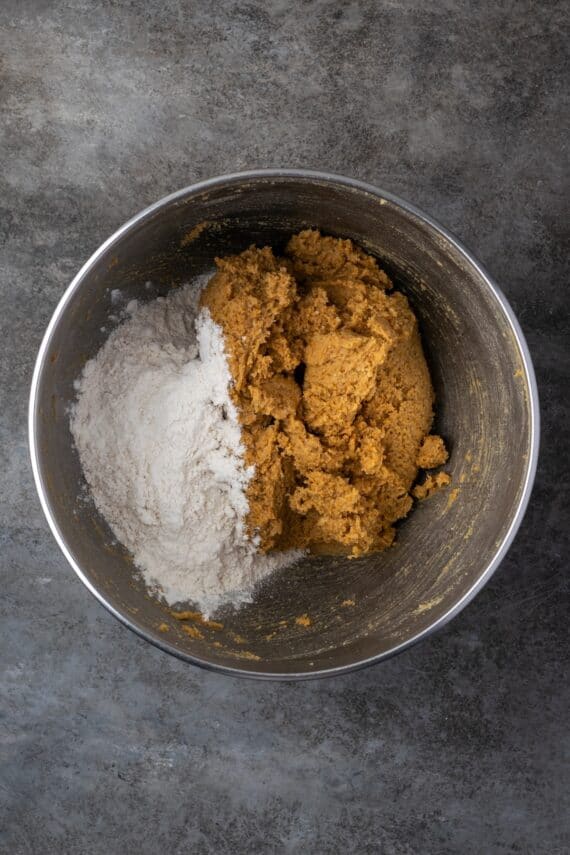 Flour added to cookie dough in a mixing bowl.