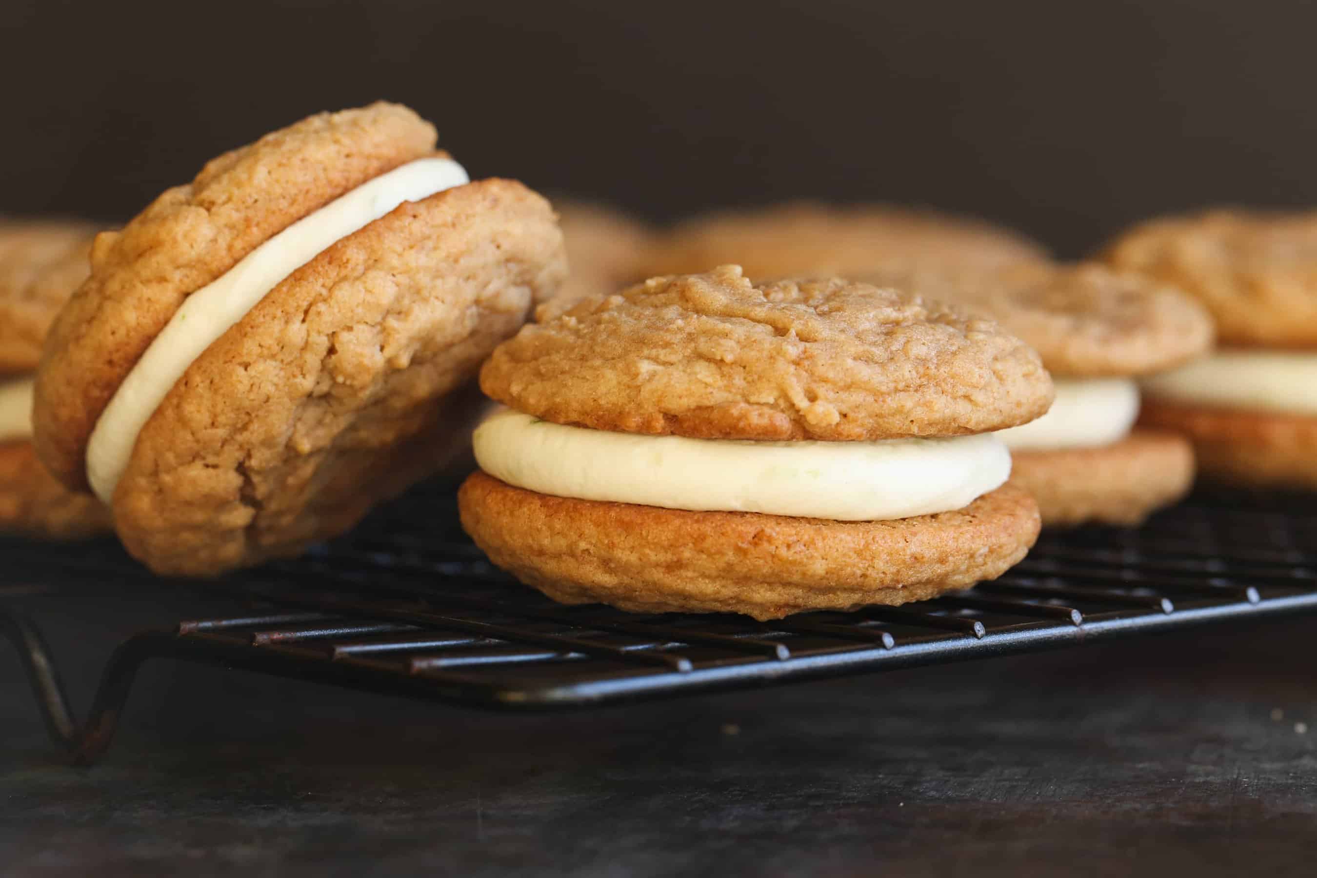 Key Lime Pie Sandwich Cookies on a black wire rack.