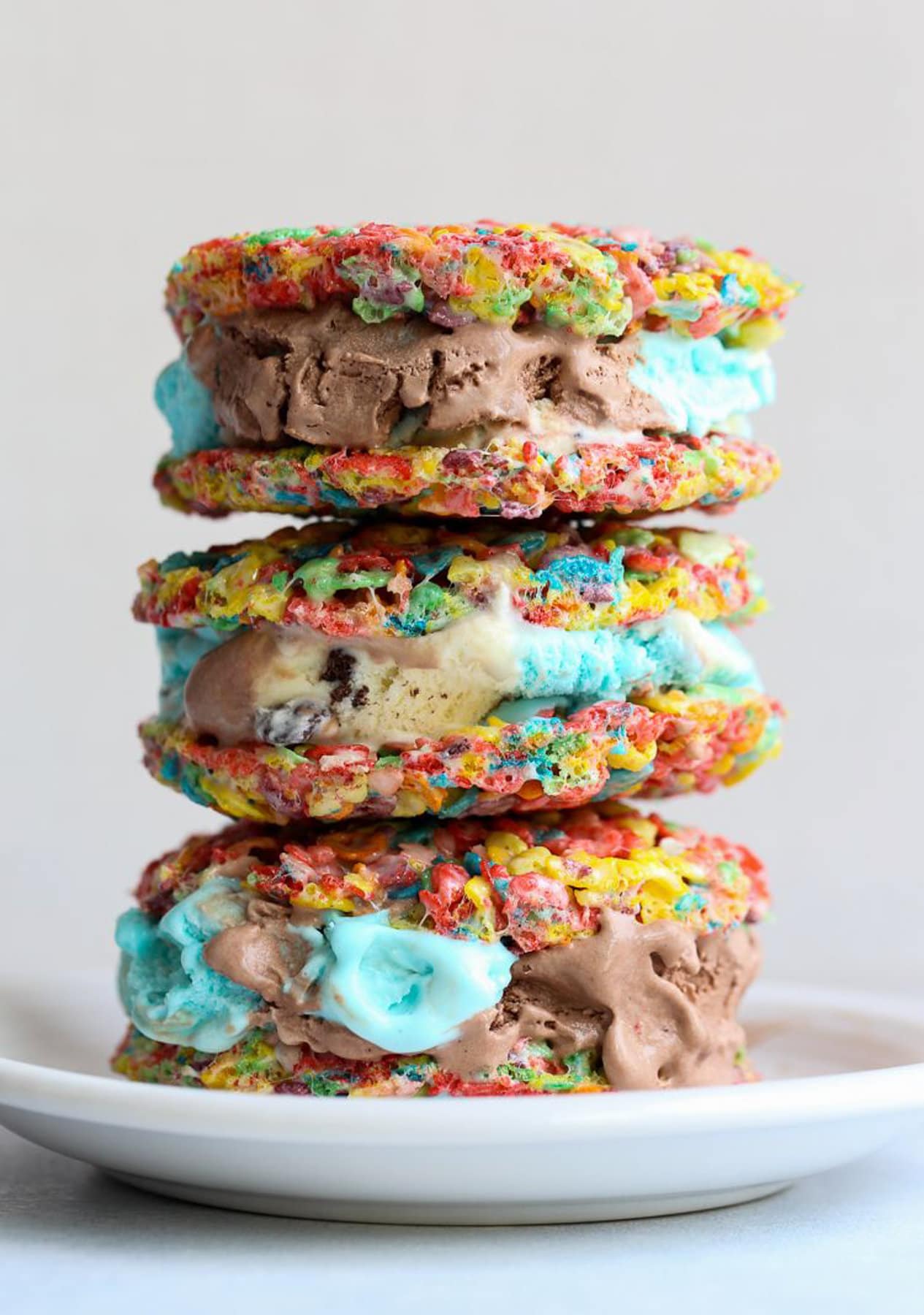 Three Fruity Pebble Ice Cream Sandwiches stacked on top of each other 