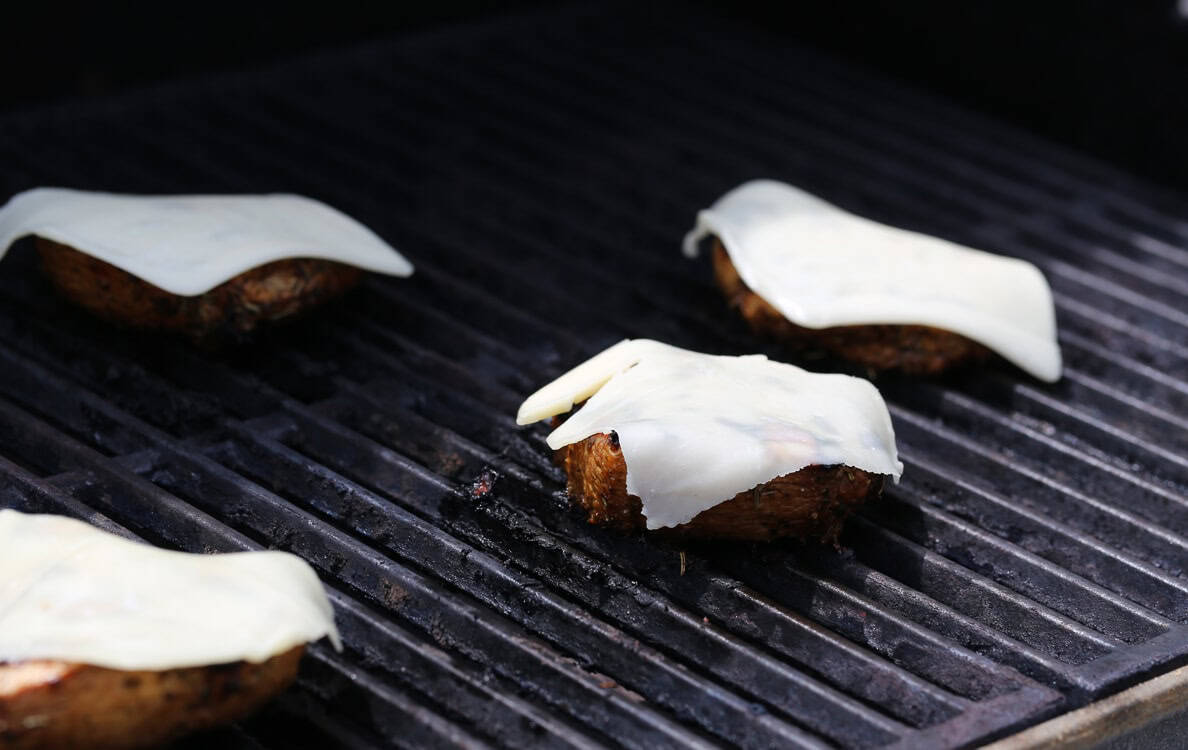 Slices of mozzarella are melted over grilled chicken.