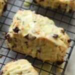 An Orange Chocolate Chunk Scone with Orange Glaze on a Wire Cooking Rack