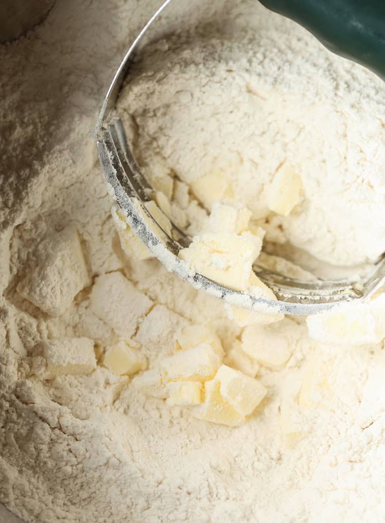 A Pastry Cutter Smooshing Butter Into the Dry Ingredients for Orange Scones