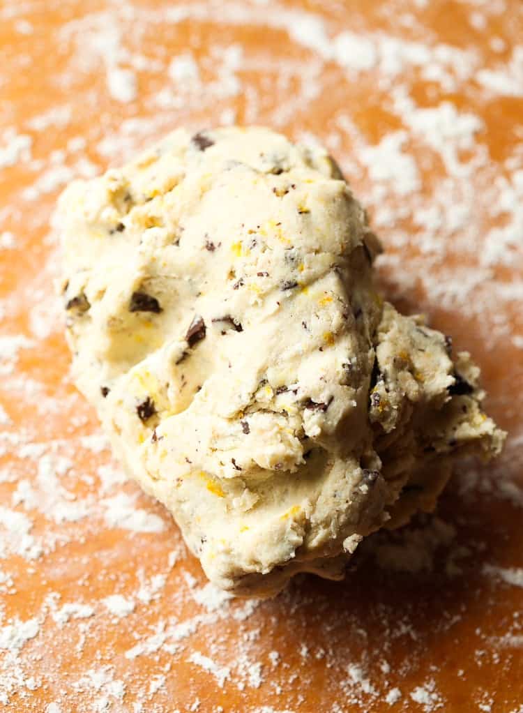 A Ball of Orange Chocolate Chunk Scone Dough on Top of a Floured Cutting Board