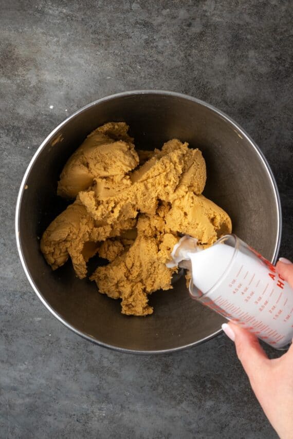 Milk added to peanut butter filling in a mixing bowl.