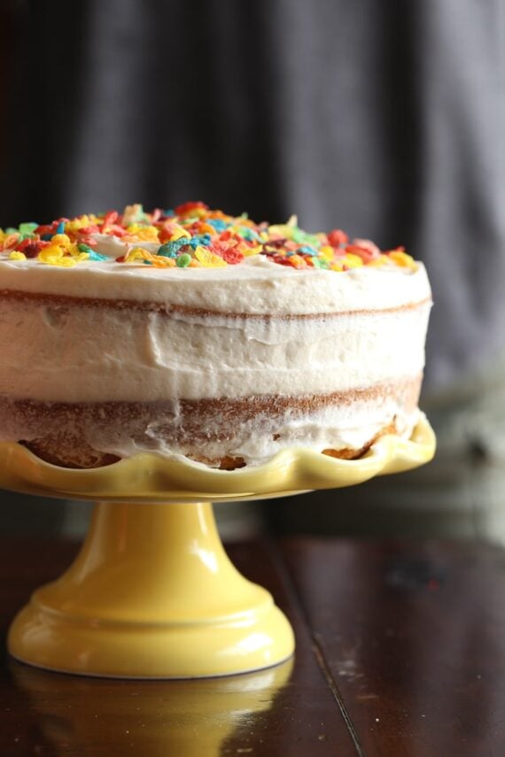 Side view of a cake with cereal milk frosting and fruity pebbles on top