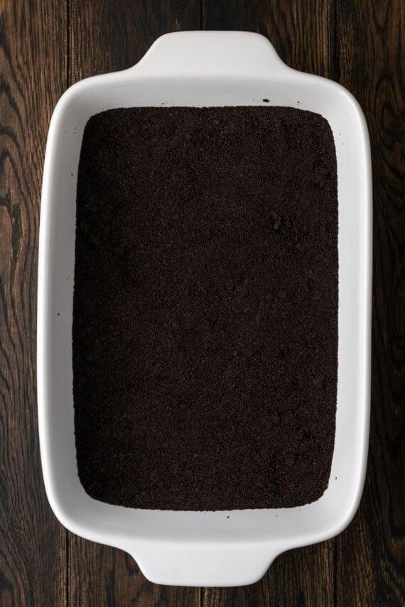 Oreo crust pressed into the bottom of a ceramic casserole dish.