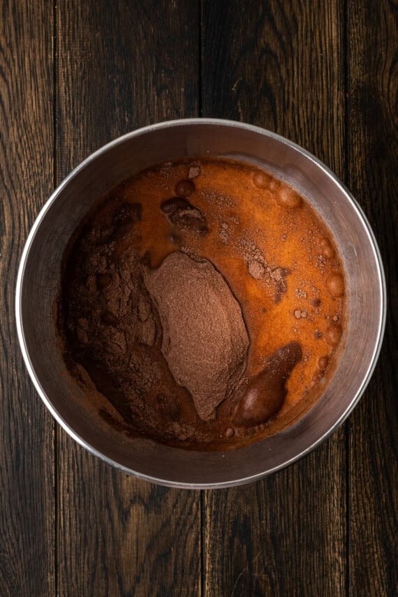 Chocolate pudding mix combined with milk in a metal bow.