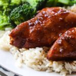 Slow cooker honey garlic chicken served on a bed of rice with broccoli.