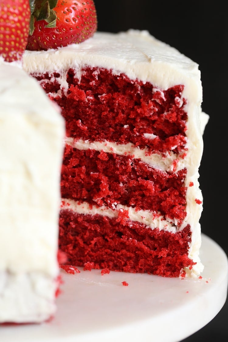 Red velvet cake with a slice taken out of it.